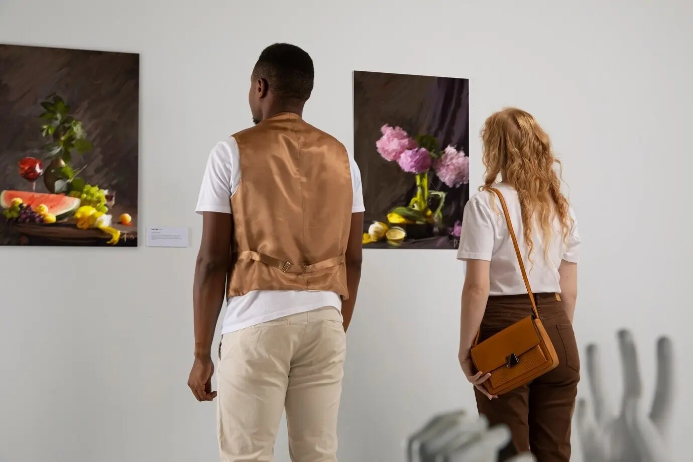 Вид сбоку: люди смотрят на картины.